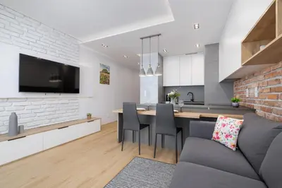 a kitchen and living room with a couch and a table at Mogilska Apartments with Parking near TAURON Arena Kraków by Noclegi Renters in Kraków