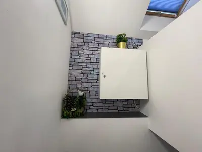 a room with a brick wall and a white refrigerator at APARTAMENT KRÓLEWSKI CENTRUM NIEPOŁOMICE in Niepołomice