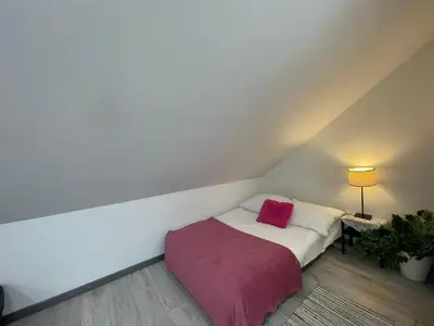 a small bedroom with a bed with a pink blanket at APARTAMENT KRÓLEWSKI CENTRUM NIEPOŁOMICE in Niepołomice