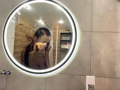 a person reflection in a mirror in a bathroom at APARTAMENT KRÓLEWSKI CENTRUM NIEPOŁOMICE in Niepołomice