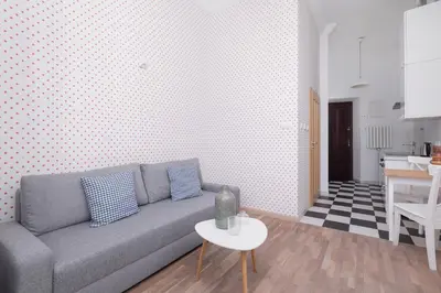 a living room with a gray couch and a table at 1-Bedroom Apartment - Brodzińskiego 3 - Podgórze in Kraków