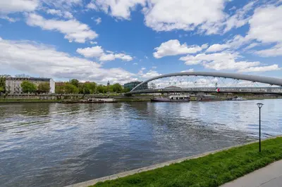 a bridge over a river next to a body of water at 1-Bedroom Apartment - Brodzińskiego 3 - Podgórze in Kraków