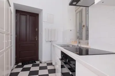 a kitchen with a sink and a black and white checkered floor at 1-Bedroom Apartment - Brodzińskiego 3 - Podgórze in Kraków
