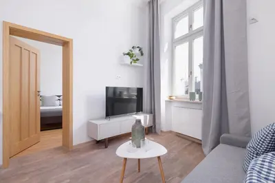 a living room with a couch and a tv and a table at 1-Bedroom Apartment - Brodzińskiego 3 - Podgórze in Kraków