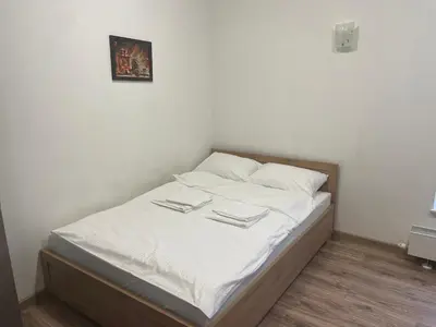 a bed with white sheets and white pillows at Apartamenty 3 Kraków Podgórze in Kraków