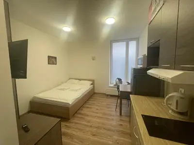 a small room with a bed and a kitchen at Apartamenty 3 Kraków Podgórze in Kraków