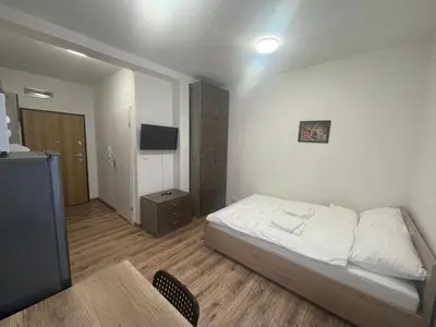 a bedroom with a bed and a table and a television at Apartamenty 3 Kraków Podgórze in Kraków