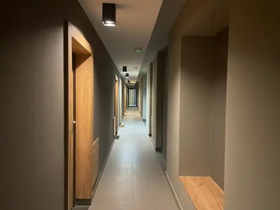 a hallway with a long corridor with many doors at Apartamenty 3 Kraków Podgórze in Kraków