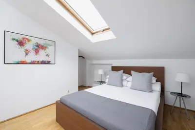 a bedroom with a bed and a painting on the wall at 1 Bedroom Apartment with AC - Dluga 65 Street in Kraków