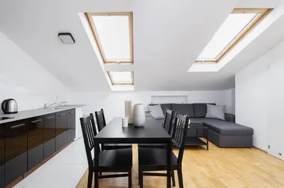 a kitchen and living room with a table and a couch at 1 Bedroom Apartment with AC - Dluga 65 Street in Kraków