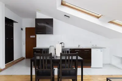 a kitchen with a black table and chairs at 1 Bedroom Apartment with AC - Dluga 65 Street in Kraków