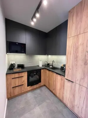 a kitchen with black counters and wooden cabinets at Apartment 41 in Kraków