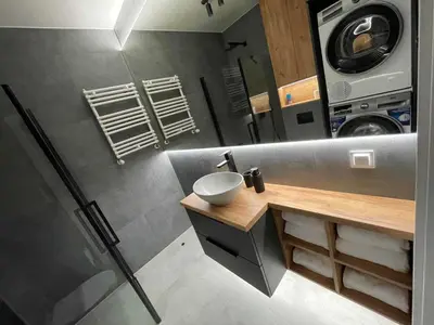 a bathroom with a sink and a washing machine at Apartment 41 in Kraków
