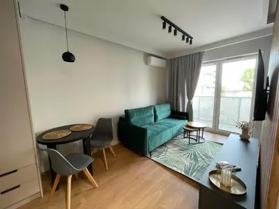 a living room with a green couch and a table at Apartment 41 in Kraków