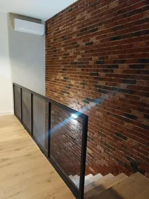 a brick wall with a metal railing in front of a building at Apartament z dużym tarasem, bezpłatny parking, AWG APARTMENTS in Kraków