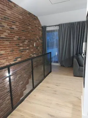 a room with a brick wall and a wooden floor at Apartament z dużym tarasem, bezpłatny parking, AWG APARTMENTS in Kraków