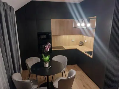 a dining room with a table and chairs and a kitchen at Apartament z dużym tarasem, bezpłatny parking, AWG APARTMENTS in Kraków