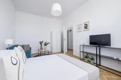 a white room with a bed and a tv at 1-Bedroom Apartment - Długa 65 in Kraków