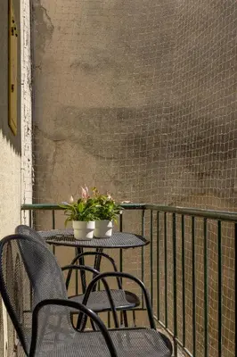 a table with two chairs and flowers on a balcony at 1-Bedroom Apartment - Długa 65 in Kraków