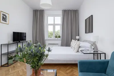 a white living room with a bed and a couch at 1-Bedroom Apartment - Długa 65 in Kraków