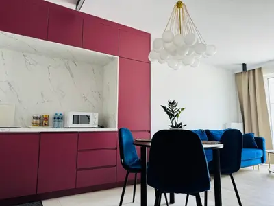 a dining room with purple walls and a table and chairs at Penthouse21 in Oświęcim