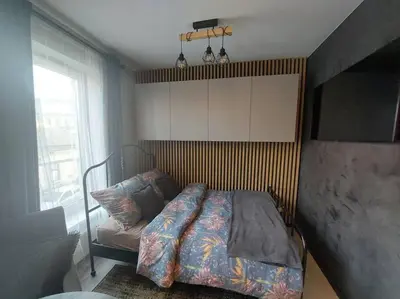 a bedroom with a bed and a large window at Wałowa Stylowe studio, AWG APARTMENTS in Kraków