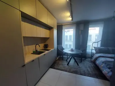a kitchen with a sink and a table in a room at Wałowa Stylowe studio, AWG APARTMENTS in Kraków