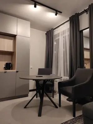 a room with a table and two chairs and a kitchen at Wałowa Stylowe studio, AWG APARTMENTS in Kraków