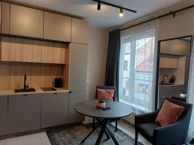 a room with a table and a chair and a kitchen at Wałowa Stylowe studio, AWG APARTMENTS in Kraków