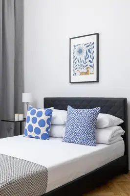 a bedroom with a bed with blue and white pillows at 1-Bedroom Apartment - 65 Długa Street in Kraków