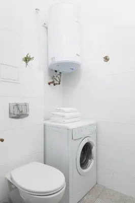 a white bathroom with a washing machine and a washer at 1-Bedroom Apartment - 65 Długa Street in Kraków
