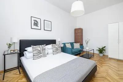 a bedroom with a bed and a blue couch at 1-Bedroom Apartment - Długa 65 street in Kraków