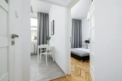 a bedroom with a bed and a desk in a room at 1-Bedroom Apartment - Długa 65 street in Kraków