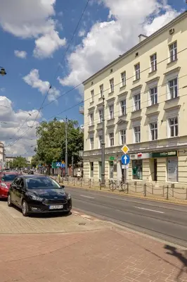 a black car parked on the side of a city street at 1-Bedroom Apartment - Długa 65 street in Kraków