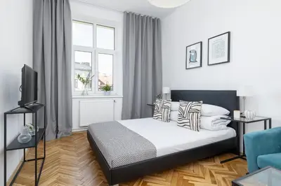 a white bedroom with a bed and a window at 1-Bedroom Apartment - Długa 65 street in Kraków