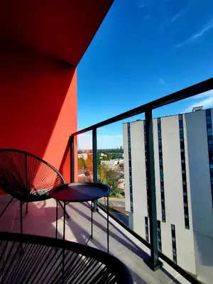 a balcony with a table and a chair on a building at Movie Nights Tauron Arena in Kraków