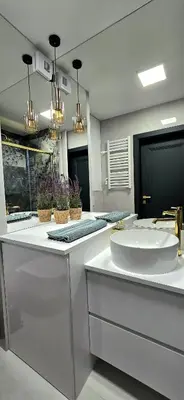 a bathroom with a large white sink and two mirrors at Movie Nights Tauron Arena in Kraków