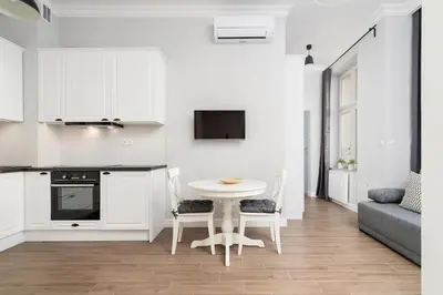 a white kitchen with a white table and chairs at Kazimierz District - Starowislna 43 in Kraków