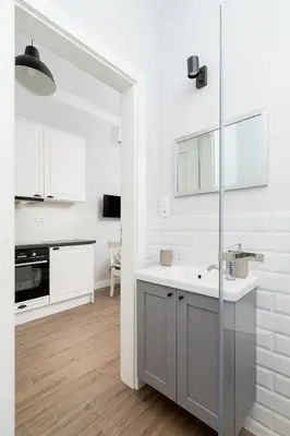 a white kitchen with white cabinets and a sink at Kazimierz District - Starowislna 43 in Kraków