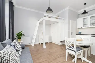 a white living room with a table and chairs at Kazimierz District - Starowislna 43 in Kraków