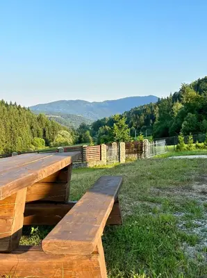 a wooden bench sitting on top of a field at Dom wypoczynkowy z widokiem na LUBAŃ in Ochotnica Dolna