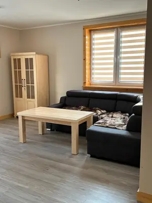a living room with a couch and a coffee table at Dom wypoczynkowy z widokiem na LUBAŃ in Ochotnica Dolna