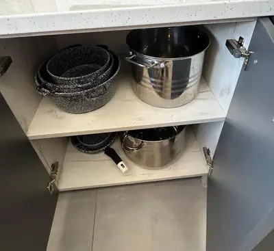 a cabinet with pots and pans on a shelf at Dom wypoczynkowy z widokiem na LUBAŃ in Ochotnica Dolna