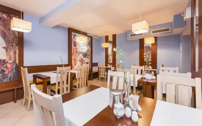 a dining room with a table and chairs at Hostel Biały Dom in Kraków