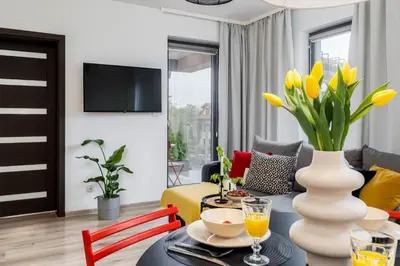 a living room with a table with yellow flowers in a vase at ICE Art by Cozyplace in Kraków