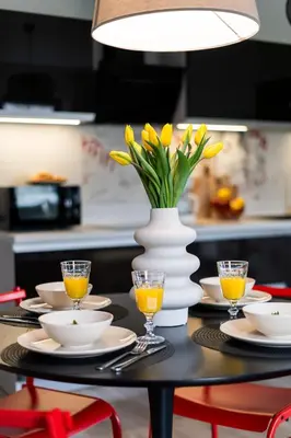 a table with a vase with yellow flowers on it at ICE Art by Cozyplace in Kraków