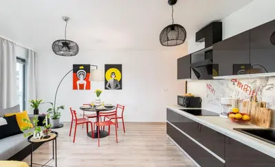 a kitchen and living room with a table and chairs at ICE Art by Cozyplace in Kraków