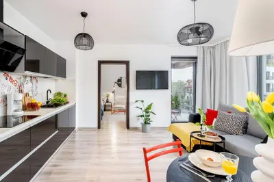 a kitchen and living room with a couch and a table at ICE Art by Cozyplace in Kraków