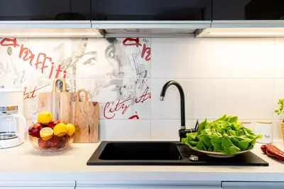 a kitchen counter with a sink and a bowl of vegetables at ICE Art by Cozyplace in Kraków
