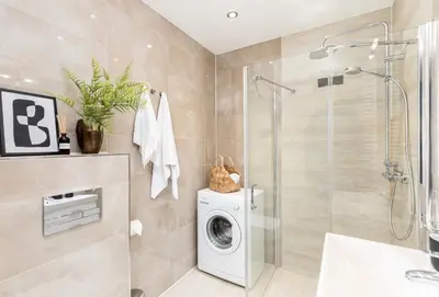 a bathroom with a washing machine and a shower at ICE Art by Cozyplace in Kraków